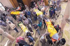  ?? Khalil Hamra/Associated Press ?? Palestinia­n mourners carry out the bodies of Rasmi Abu Malhous and seven members of his family who were killed in overnight Israeli missile strikes.