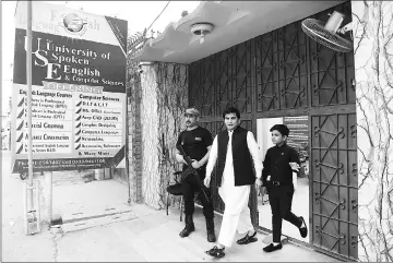  ??  ?? In this picture taken on April 3, 11-year-old Pakistani motivation­al coach Hammad Safi (Right) walks with his teacher at a languages academy in Peshawar. Elegantly dressed, his gestures confident, Hammad Safi speaks into a wireless microphone before an...