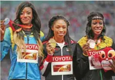  ??  ?? BEIJING: (L-R) Bahamas’s silver medallist Shaunae Miller, USA’s gold medallist Allyson Felix and Jamaica’s bronze medallist Shericka Jackson pose with their medals on the podium during the victory ceremony for the women’s 400 metres athletics event at...