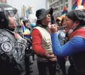  ??  ?? A supporter of Bolivia’s former President Evo Morales confronts a police officer Tuesday in La Paz.