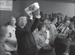  ?? EVAN VUCCI, THE ASSOCIATED PRESS ?? President Donald Trump tosses paper towels into a crowd as he hands out supplies at Calvary Chapel in Guaynabo, Puerto Rico. Trump has been slammed for his insults directed at the storm-ravaged territory.