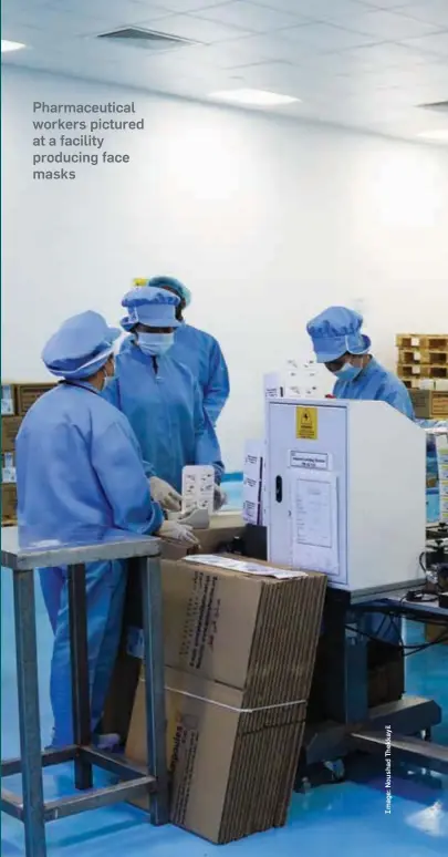  ??  ?? Pharmaceut­ical workers pictured at a facility producing face masks