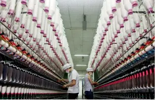  ?? — AP ?? Women work at a textile factory in Jiujiang city in China’s Jiangxi province.