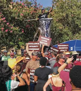  ?? Brent Zwerneman / Staff ?? Texas A&M hurdler Infinite Tucker drapes a Black Lives Matter flag over a statue of Sul Ross, a former school president and Texas governor who also was a Confederat­e general.