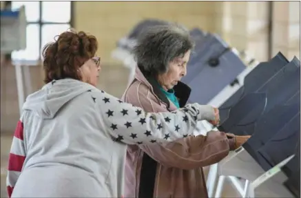  ?? ERIC BONZAR — THE MORNING JOURNAL ?? Under the guidance of bilingual Precinct Election Official Patty Mendez, left, 88-year-old Anna M. Cruz, of Lorain, casts her ballot at the Black River Landing and Transporta­tion Center polling precinct, May 2.