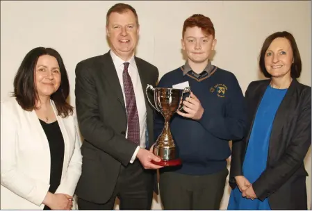  ??  ?? Aine O’ Sullivan, director of schools KWETB; Alan Wright EDCO, sponsor, presenting the first prize cup to Ross Bailey, Colaiste Bhride and deputy principal, Anna Gahan.