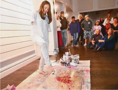  ?? Brian A. Pounds/Hearst Connecticu­t Media ?? Born without forearms, artist Rosie Jon makes a painting with her feet during the art opening of her work at The Gallery at Green’s Farms Church in Westport on Nov. 1. More examples of Jon’s work are shown below.