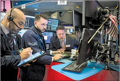  ?? Bloomberg News/MICHAEL NAGLE ?? Traders work Friday on the floor of the New York Stock Exchange, where investors’ worries over trade tensions led to another day of widespread losses.