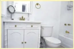  ??  ?? The bathrooms are all-white with gold hardware and plumbing fixtures.