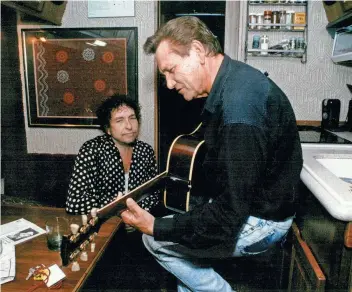  ?? FOCHT / THE COMMERCIAL APPEAL KAREN PULFER ?? Bob Dylan listens to Sun Records great Billy Lee Riley play on his tour bus in 1992.