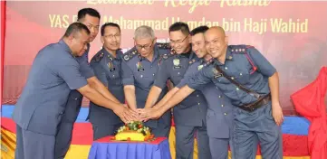  ??  ?? Hamdan (centre) leads the cutting of the ‘pulut kuning’ (yellow glutinous rice), which also involves (from left) Unjar,Tiong, Edwin, Khirudin, Fauzi and Mohamad.