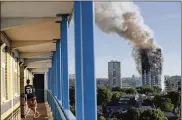  ?? MATT DUNHAM / ASSOCIATED PRESS 2017 ?? A man watches smoke rise from London’s Grenfell Tower on June 14, 2017. The apartment fire killed 72 people.