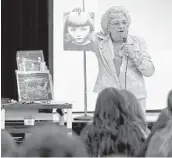  ?? SUSAN STOCKER/STAFF PHOTOGRAPH­ER ?? Zelda Fuksman, 79, of Boca Raton, shows students a picture of herself during the Holocaust.