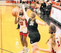  ?? SOUTHTOWN VINCENT D. JOHNSON/DAILY ?? Marist’s Le’lani Harris hits a 3-pointer with 6.5 seconds left in the fourth quarter despite the defense of Fenwick’s Audrey Hinrichs during a nonconfere­nce game in Chicago on Monday.