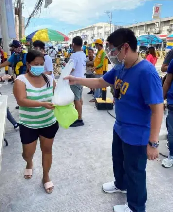  ?? (Chris Navarro) ?? COMMUNITY PANTRY. Mabalacat City Vice Mayor Geld Aquino distribute­s rice in support of the community pantry of Our Lady of Victory Parish in Barangay Dau last Friday. The presiding officer of the Sanggunian Panlunsod also gave rice to police, barangay and health frontliner­s and several community pantries.