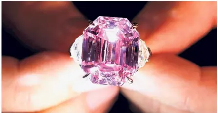  ?? — Reuters ?? Big and beautiful: A Christie’s staff holding the ‘fancy vivid’ pink diamond during a preview in Geneva.