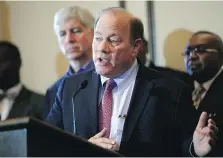  ?? JOSHUA LOTT/GETTY IMAGES ?? Detroit Mayor Mike Duggan, centre, speaks during a news conference Nov. 7, 2014, after a U.S. judge gave the City of Detroit the OK to plan an exit strategy from Chapter 9 bankruptcy.