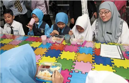  ?? — File photo ?? Watchful eyes: Habibah visiting SK Seri Suria, Kuala Lumpur, to check on the first day of the free breakfast programme for pupils last year before the start of the pandemic.