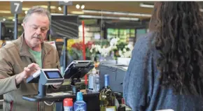  ?? JOURNAL SENTINEL ZHIHAN HUANG / MILWAUKEE ?? Reed Kailing checks out his groceries at Sendik’s Mequon store on Wednesday. Sendik’s installed more than 120 protective plastic shields at checkout lanes to protect customers and employees from the coronaviru­s.