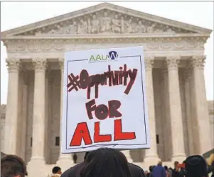  ?? Jacquelyn Martin Associated Press ?? A PROTESTER holds a sign in support of affirmativ­e action outside the Supreme Court in 2015. The court is hearing new affirmativ­e action cases this year.