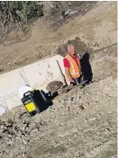  ?? PHOTO: JANE CARLYON ?? Water course . . . Volunteer Ben Gold works on a culvert to take stormwater and drain the area above the road in 2015.