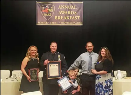  ?? NICHOLAS BUONANNO— NBUONANNO@TROYRECORD.COM ?? Troy Police Officer Ralph Southworth Jr. poses for a photo with his family after receiving the John J. Givney award Thursday morning. Pictured from left, Southworth’s girlfriend Renee Behrens, Ralph Southworth Jr., Southworth’s mother and son DeEtta...