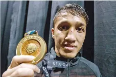  ??  ?? With a bruised nose, boxer Muhammad Fuad Mohd Redzuan proudly shows the gold medal that he won after defeating Thailand’s Thani Narinram, in the Light Fly (49kg) category at MITEC yesterday. Muhammad Fuad won the match 5-0 and the gold medal for...