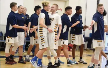  ?? DAVID BEBEE, RECORD STAFF ?? St. Benedict players celebrate their CWOSSA senior boys’ Triple A basketball title after beating Brantford’s North Park Trojans, 45-24.