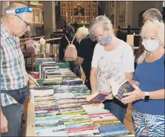  ??  ?? WELL READ David Black looking after the bookstall as Deborah Lance and Denise Barlow browse