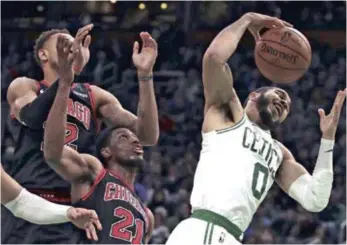  ??  ?? Jayson Tatum, alero de los Celtics de Boston, atrapa un rebote frente a Thaddeus Young, de los Bulls de Chicago./AP