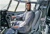  ??  ?? Taliban fighter sits in the cockpit of an Afghan Air Force aircraft at the airport in Kabul
