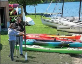  ?? PETE BANNAN — DIGITAL FIRST MEDIA ?? Jake Schaff and Tim Yatcilla wait for customers at Marsh Creek Outfitters on the lake at Marsh Creek State Park.