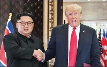  ?? SAUL LOEB/AFP ?? US President Donald Trump (right) and North Korea’s leader Kim Jong-un shake hands following a signing ceremony during their historic US-North Korea summit in Singapore on June 12.