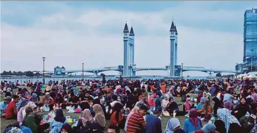  ?? PIC BY GHAZALI KORI ?? People breaking fast at an area overlookin­g the drawbridge in Kuala Terengganu recently.