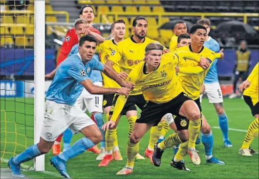  ??  ?? Rodrigo agarra a Haaland en un córner durante el partido que enfrentó ayer al Dortmund con el City.