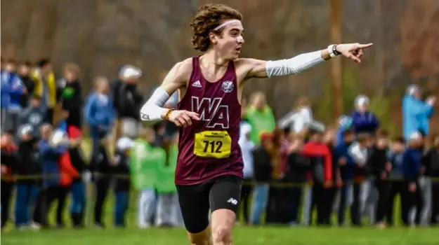  ?? ANDREW BURKE-STEVENSON FOR THE GLOBE ?? Spectators get the point as Westford’s Paul Bergeron closes in on the finish line during the Division 1 boys race at the Meet of Champions.