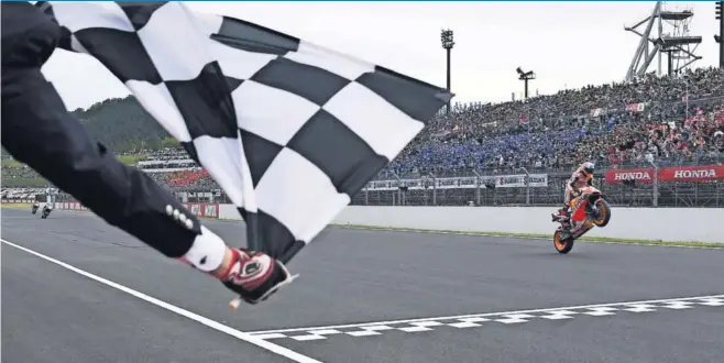  ??  ?? Marc Márquez cruza victorioso la meta en Motegi tras conseguir su décima victoria de la temporada en la que ha logrado su octavo título, sexto en la máxima categoría.