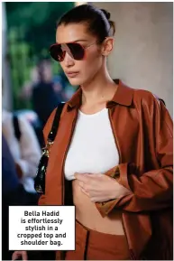  ?? ?? Bella Hadid is effortless­ly stylish in a cropped top and shoulder bag.
