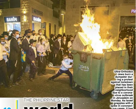  ??  ?? Ultra-Orthodox Jews burn a dumpster during a protest against lockdown that has been placed in their neighborho­od due to a coronaviru­s outbreak in Jerusalem on Monday. As Israel grapples with a spike in coronaviru­s cases, it has started to impose restrictio­ns on selected towns with high infection rates. AP