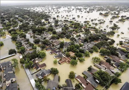  ?? DAVID J. PHILLIP / ASSOCIATED PRESS ?? Water from the Addicks Reservoir flows into neighborho­ods in Houston on Tuesday as flooding from Tropical Storm Harvey continues to rise. One gauge recorded 51.1 inches of rain, and between 20 and 30 percent of Harris County is underwater.