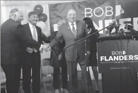  ?? Photos by Ernest A. Brown ?? Richard McAdams, left, and Alan Hassenfeld, former chairman and CEO of Hasbro Toys, center, congratula­te Bob Flanders after announcing his candidacy for U.S. Senate in a converted warehouse in Central Falls Thursday morning.