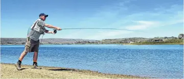  ??  ?? Take that . . . Cromwell fisher Tony Conaboy casts an imitation blowfly to fish he can see feeding on the edge of the reservoir.