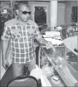  ??  ?? Jagdeo Seecharan shows where bandits broke the showcase at Savi Classic Jewellery, Couva yesterday.