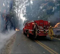  ?? ANDA CHU — STAFF PHOTOGRAPH­ER ?? A Cal Fire crew drives along Chalk Hill Road past spot fires in Healdsburg east of Windsor on Sunday.