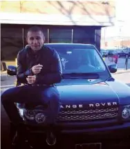  ??  ?? CONSPICUOU­S WEALTH: Khurtsidze adjusts his leather jacket as he sits on a Range Rover