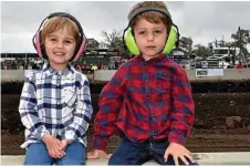  ??  ?? Twins Ruby and Charlie Corbett of Biddeston protect their ears from the loud sounds of the tractor pull.