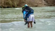  ?? JULIO CESAR AGUILAR / GETTY IMAGES ?? RISKING IT: Honduran migrants try to cross the Rio Bravo into Eagle Pass, Texas, from Piedrea Negras, Mexico, Thursday.