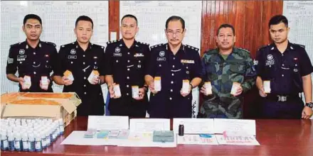  ?? PIC BY NIK ABDULLAH NIK OMAR ?? Pasir Mas police chief Assistant Commission­er Abdullah Mohammad Piah (third from right) with the illicit drugs seized in raids, in Pasir Mas yesterday.