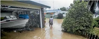  ?? BRADEN FASTIER/NELSON MAIL ?? A woman walks through a flooded Riwaka property in the wake of ex-Cyclone Gita last week.