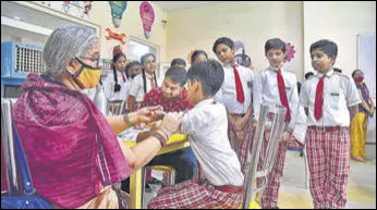  ?? PTI ?? A health care worker administer­s a dose of a Covid-19 vaccine to a student in Bikaner.